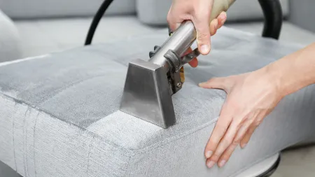 a person cleaning upholstery