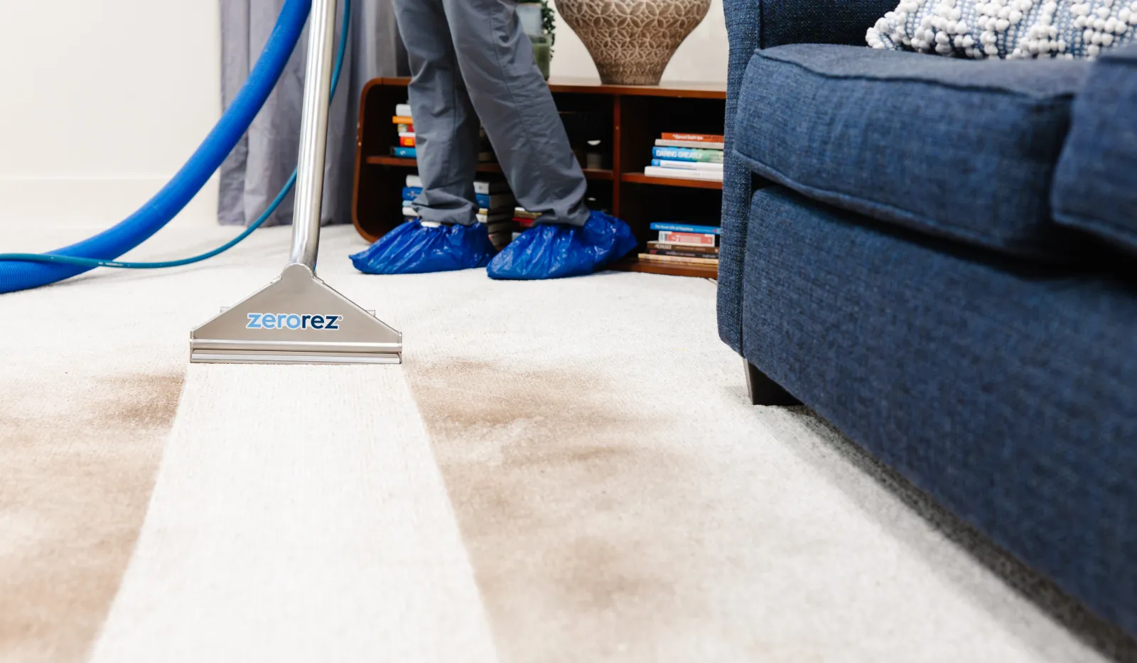 Professional carpet cleaning showing a clear, fresh cleaned path on a stained carpet in a living room.