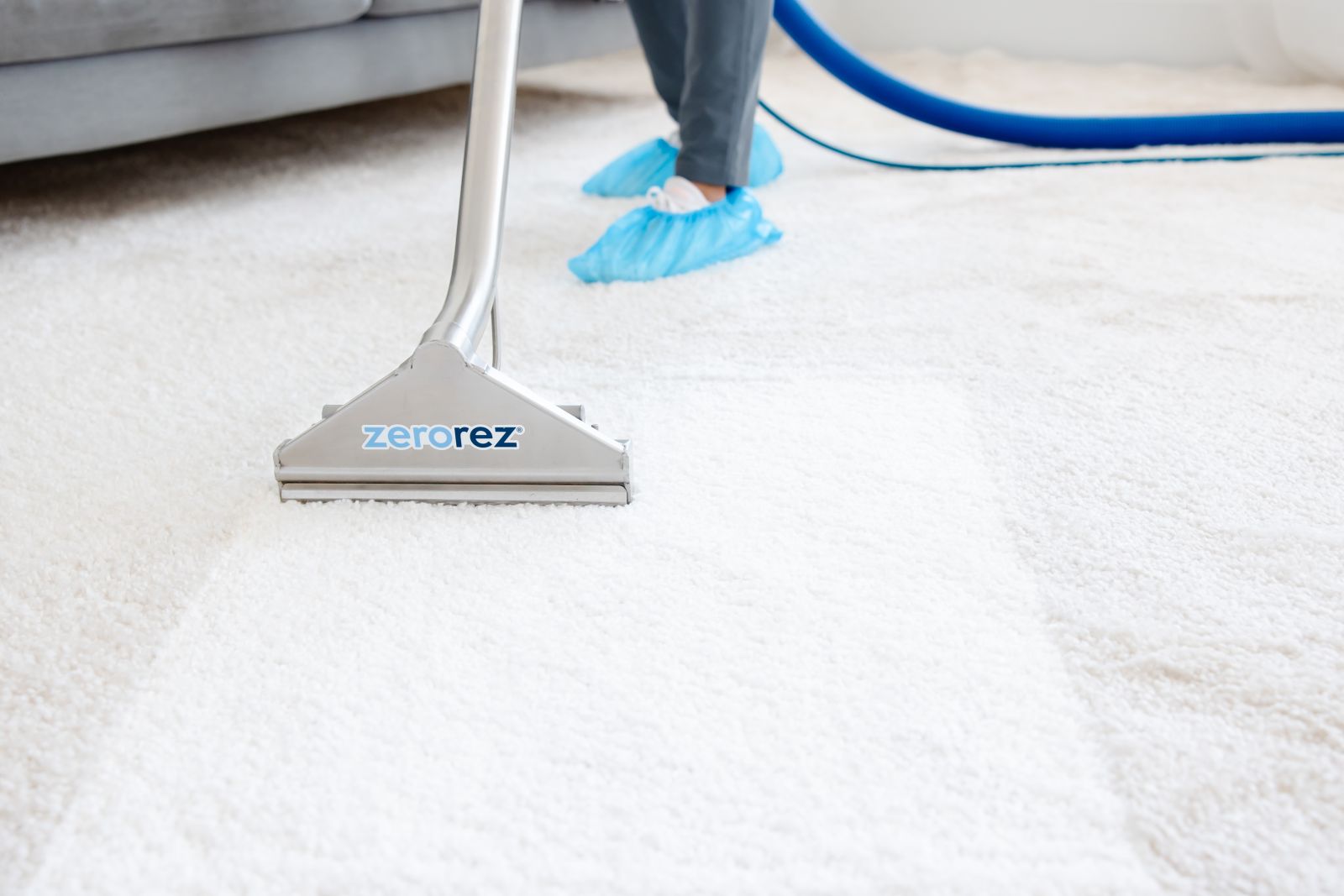 Zerorez&reg; Zr&trade; Wand cleaning a white carpet, with a stripe forming as it cleans between before/after carpet cleaning