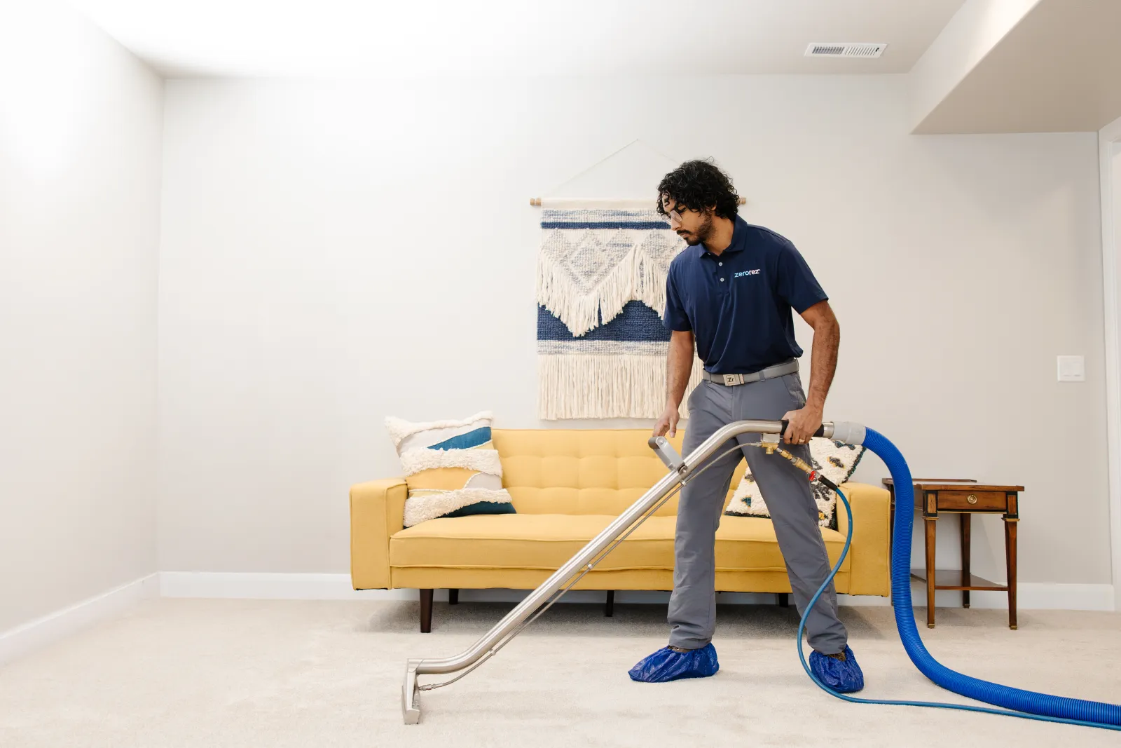 technician cleaning carpet in a home living room with white carpet